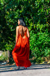 Rear view of female model standing on road at park