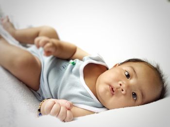 Close-up portrait of baby lying on bed