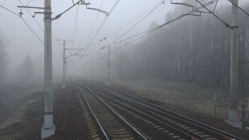 Railroad tracks against sky during foggy weather