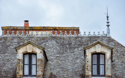 Dormer windows on slate roof and orange chimneys. rochefort-en-terre, french brittany