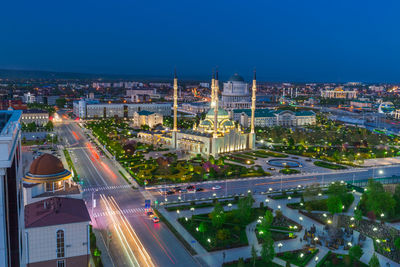 High angle view of illuminated city street and buildings at night