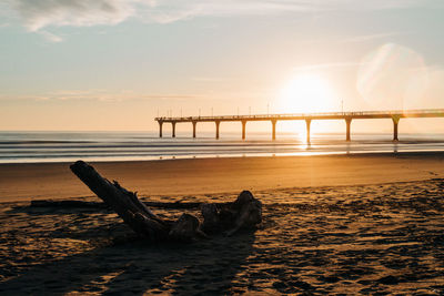 Bridge over sea against sky during sunset