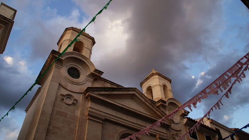 Low angle view of decorated building against cloudy sky