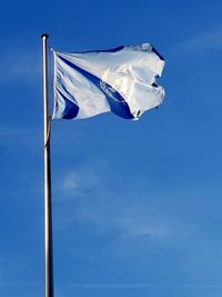 Low angle view of united nations flag against blue sky