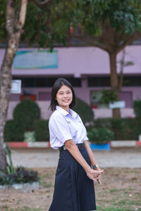 Portrait of young woman standing outdoors