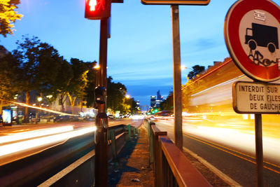 Light trails on road against sky at night