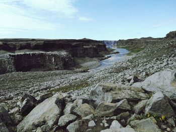 Scenic view of rocky shore against sky