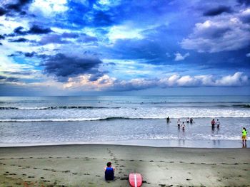 People at beach against sky