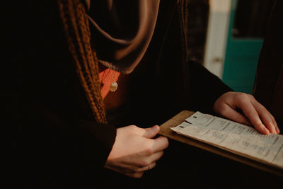 Midsection of woman reading book