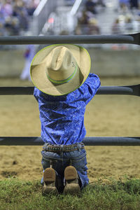 Rear view of person standing against wall