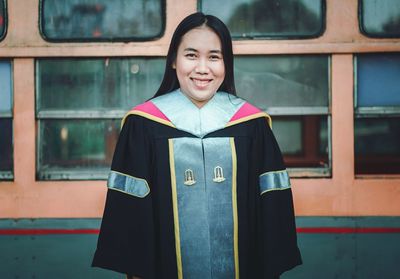 Portrait of smiling young woman in graduation gown