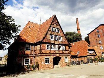 Residential buildings by street against sky