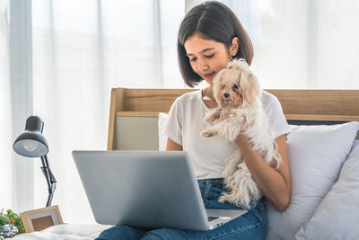 Portrait of woman with dog at home