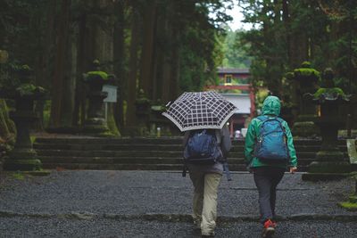 Rear view of people walking on footpath