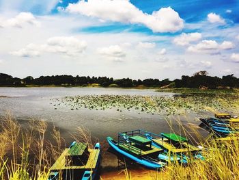 Boats moored on lake against sky