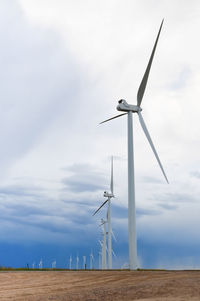 Low angle view of windmill on field against sky