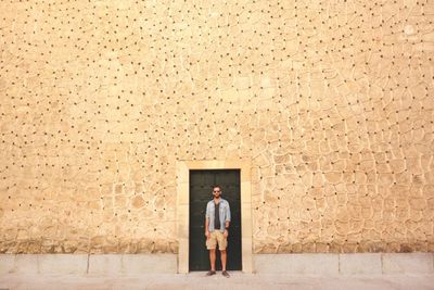 Man standing against closed door of old building