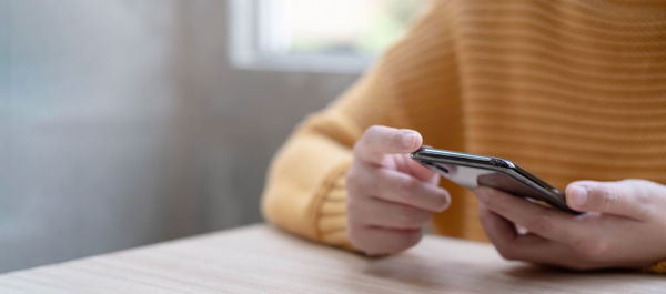 Close-up of woman holding hands on table