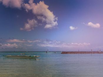 Boats in sea against cloudy sky