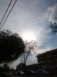 Cars on street by buildings against sky