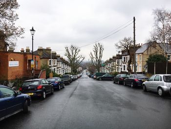 Cars on road in city against sky