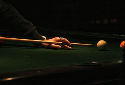 Midsection of man playing pool