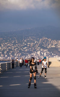 People on road in city against sky