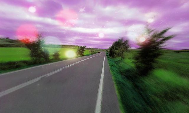 sky, the way forward, road, landscape, transportation, field, cloud - sky, tranquil scene, grass, diminishing perspective, sunset, tranquility, nature, tree, country road, beauty in nature, scenics, growth, vanishing point, cloud