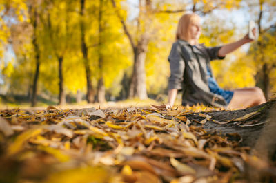 Woman with autumn leaves in forest