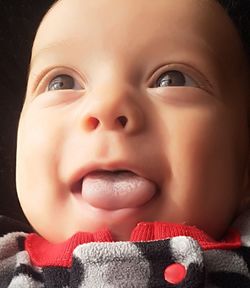 Close-up of cute baby sticking out tongue