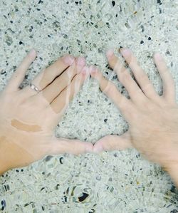 Close-up of hands against water