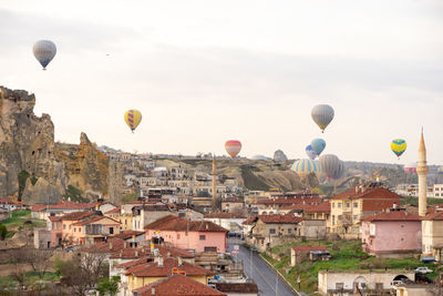 Hot air balloon flying over buildings in city