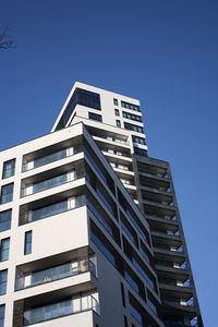 Low angle view of modern building against clear blue sky