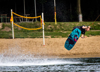 Full length of a swing hanging on water