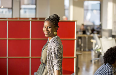 Portrait of happy businesswoman standing in office