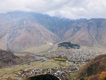 Aerial view of townscape and mountains against sky