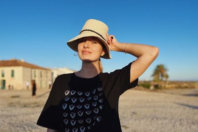 Portrait of young woman standing at beach