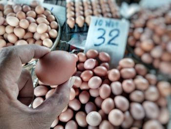 Close-up of hand holding vegetables at market stall