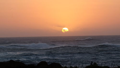 Scenic view of sea against orange sky