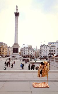 People on street at trafalgar square against sky