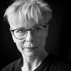 Close-up portrait of mature woman against black background