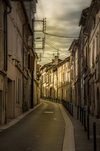 Empty road along buildings