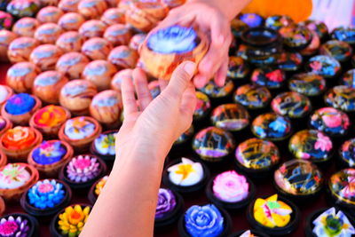 Cropped hand giving flower to customer