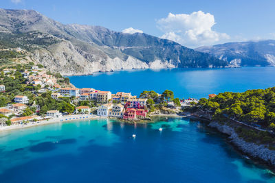 Scenic view of sea by mountains against sky