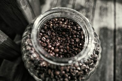 High angle view of roasted coffee beans in glass jar on table
