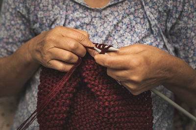 Midsection of woman knitting wool