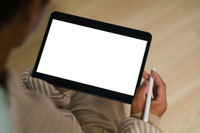 Midsection of woman using digital tablet