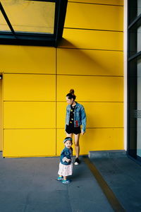 Full length of boy with yellow umbrella