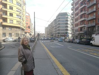 Portrait of smiling woman standing on road in city