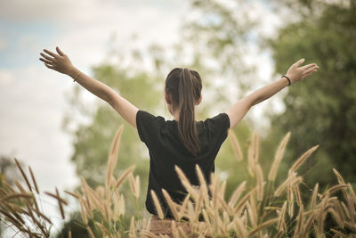 Rear view of woman standing in farm